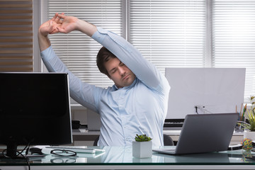 Tired Businessman Stretching His Arms