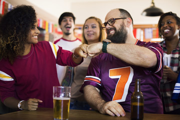 Friends cheering sport at bar together