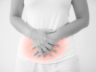 Woman having a stomachache, or menstruation pain with white background. Health care and medical concept.