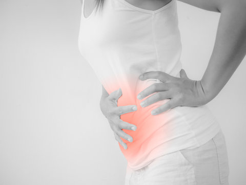 Woman having a stomachache, or menstruation pain with white background. Health care and medical concept.