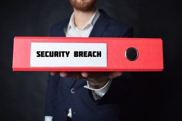 A businessman holds a folder with the inscription:SECURITY BREACH