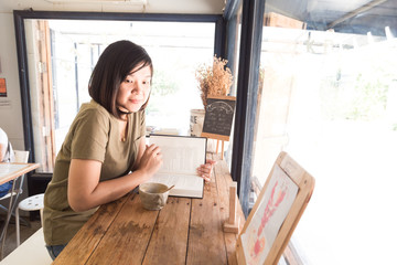 Women reading book on wood table of coffee shop