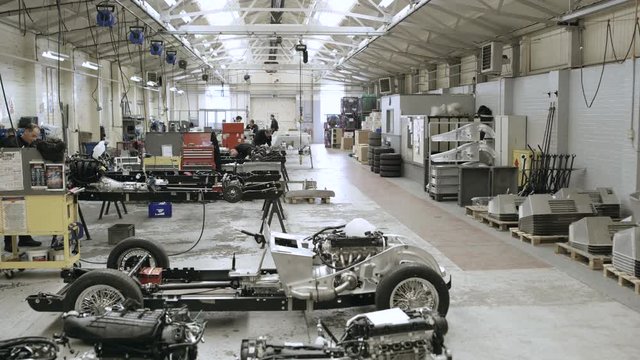 Automobile sports car manufacturing plant engineers working on vehicles