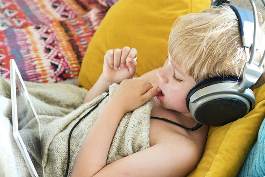 Boy using digital tablet on sofa