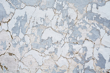 Gebarsten en verontrust geschilderd oppervlak aan de zijkant van een gebouw of muur. Beton- of cementtextuur met afbladderende oude verf.
