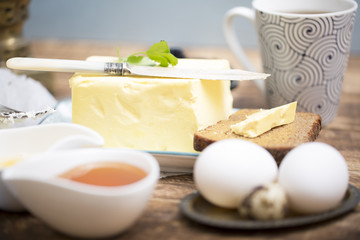 Breakfast table with bread slice, butter, black caviar, milk and honey 