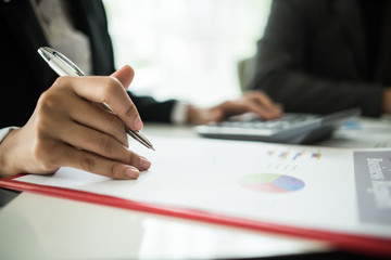 Close up of business people working with business document during discussion at meeting.
