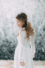 Beautiful young bride in boudoir dress on canvas background with paint. Wedding trends and ideas 2018, spring inspiration. Wedding in the Studio