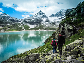 sportive couple hiking in a dreamlike mountain scenery in the european alps with view of a glacier...