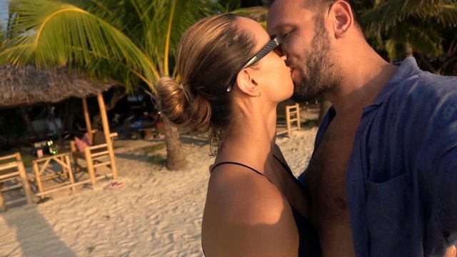 Couple kissing on beach while recording selfie video, super slow motion
