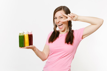 Fun woman holds row of green, red, yellow detox smoothies in bottles isolated on white background. Proper nutrition, vegetarian drink, healthy lifestyle, dieting concept. Copy space for advertisement.