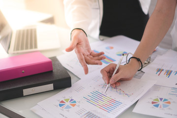Business documents on computerized graphs and graphs. And plan the network size. The team is behind the scenes. Top view shot.