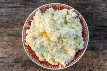 Homemade cottage cheese on old wooden table