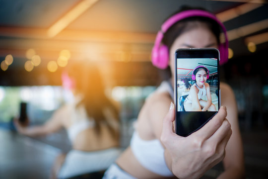 Beautiful girl in the gym taking a picture herself. With music. selfie. Copy space.