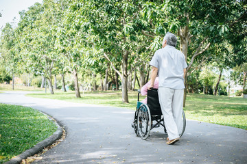 Fototapeta premium Senior man caring for disabled wife in his wheelchair.