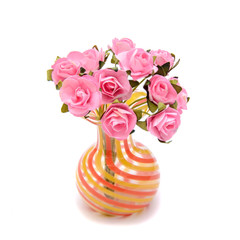 Bouquet of small artificial pink roses in a miniature glass vase