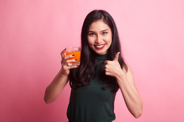 Young Asian woman thumbs up drink orange juice.