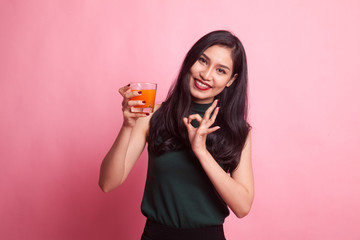 Young Asian woman show OK drink orange juice.