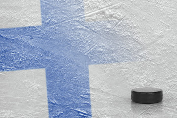 Obraz premium Hockey puck and the image of the Finnish flag on the ice