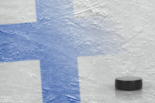 Hockey puck and the image of the Finnish flag on the ice