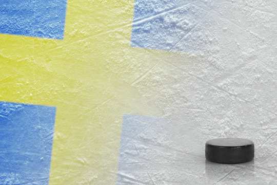 Hockey puck and the image of the Swedish flag on the ice