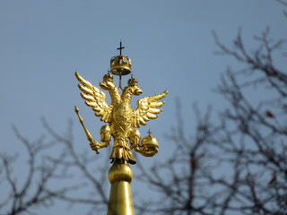 Coat of arms of Russia. Russian two-headed eagle on top of a tower at the Red square in Moscow. View through the branches