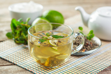 cup of black tea with mint leaves on a wooden table