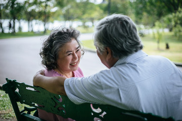 healthy senior couple relaxing  seats on Chair in the park