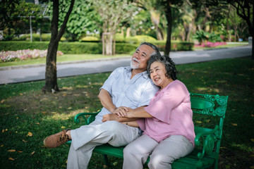 healthy senior couple relaxing  seats on Chair in the park