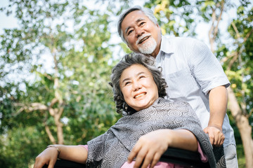 Naklejka premium Senior man caring for disabled wife in his wheelchair.
