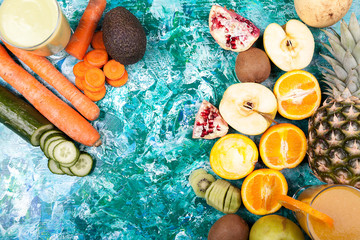 Top view of fruits, vegetables and detox juices on colorful background