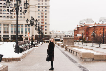 Portrait in full growth, Russian beautiful woman in a mink coat on the Red Square in Moscow in Christmas time