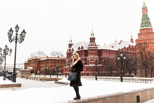 Portrait in full growth, Russian beautiful woman in a mink coat on the Red Square in Moscow in Christmas time