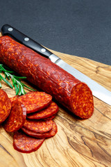 Dried organic salami sausage on wooden cutting board