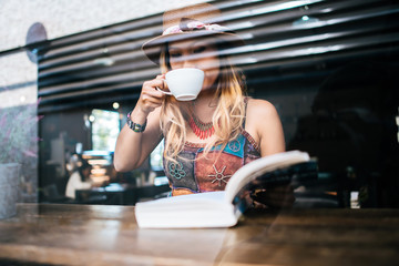  woman is holding a cup of hot cappuccino and reading a book, Business woman read a book in coffee shop