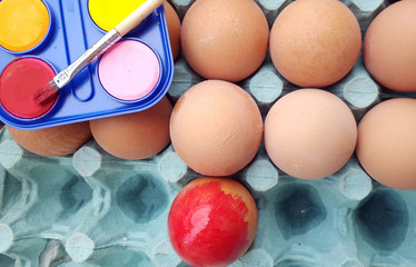 Painted easter eggs with red paint with brush and colorful paint