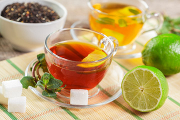cup of black tea with mint leaves on a wooden table