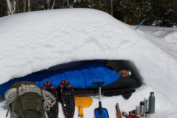 Man is sleeping in a snow cave, cross section