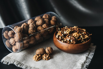 Walnuts kernels in wood bowl on dark desk, Walnut with color background, Whole walnuts in wood vintage bowl. rustic