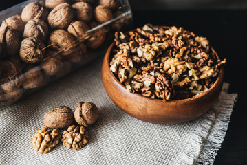 Walnuts kernels in wood bowl on dark desk, Walnut with color background, Whole walnuts in wood vintage bowl. rustic