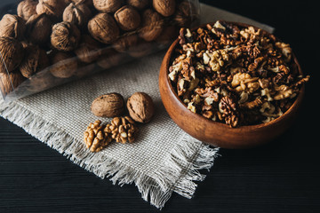 Walnuts kernels in wood bowl on dark desk, Walnut with color background, Whole walnuts in wood vintage bowl. rustic