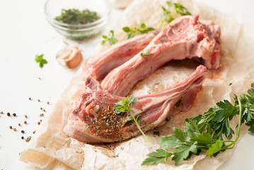 Fresh meat with spices on baking paper on white table