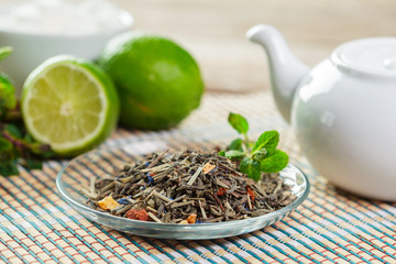 cup of black tea with mint leaves on a wooden table