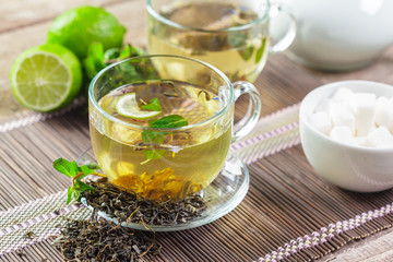 cup of black tea with mint leaves on a wooden table