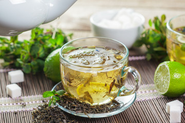 cup of black tea with mint leaves on a wooden table