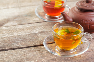 cup of black tea with mint leaves on a wooden table
