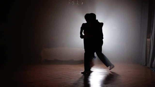 Couple dancing salsa in the fog