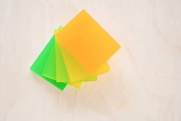 Colorful pieces of plexiglass on a wooden background.