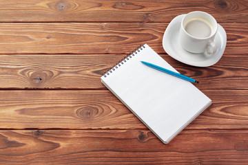 Office desk table top view. Notepad with blank pages on wooden table