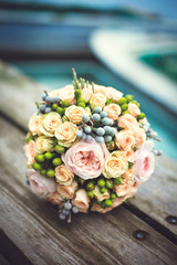 wedding bouquet of roses on old wooden table